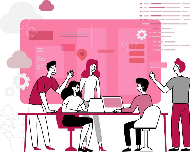 A team working together around a desk in front of a large screen